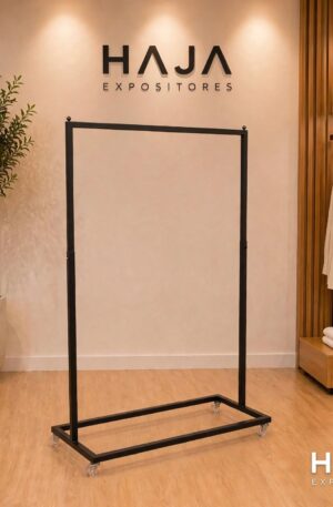 Arara Preta de Roupa Simples com Rodas de 1.7 metros de altura por 1.5 metros de largura, com pintura eletrostática preta fosca e rodinhas de silicone, posicionada em showroom elegante com o logotipo da HAJA Expositores ao fundo.